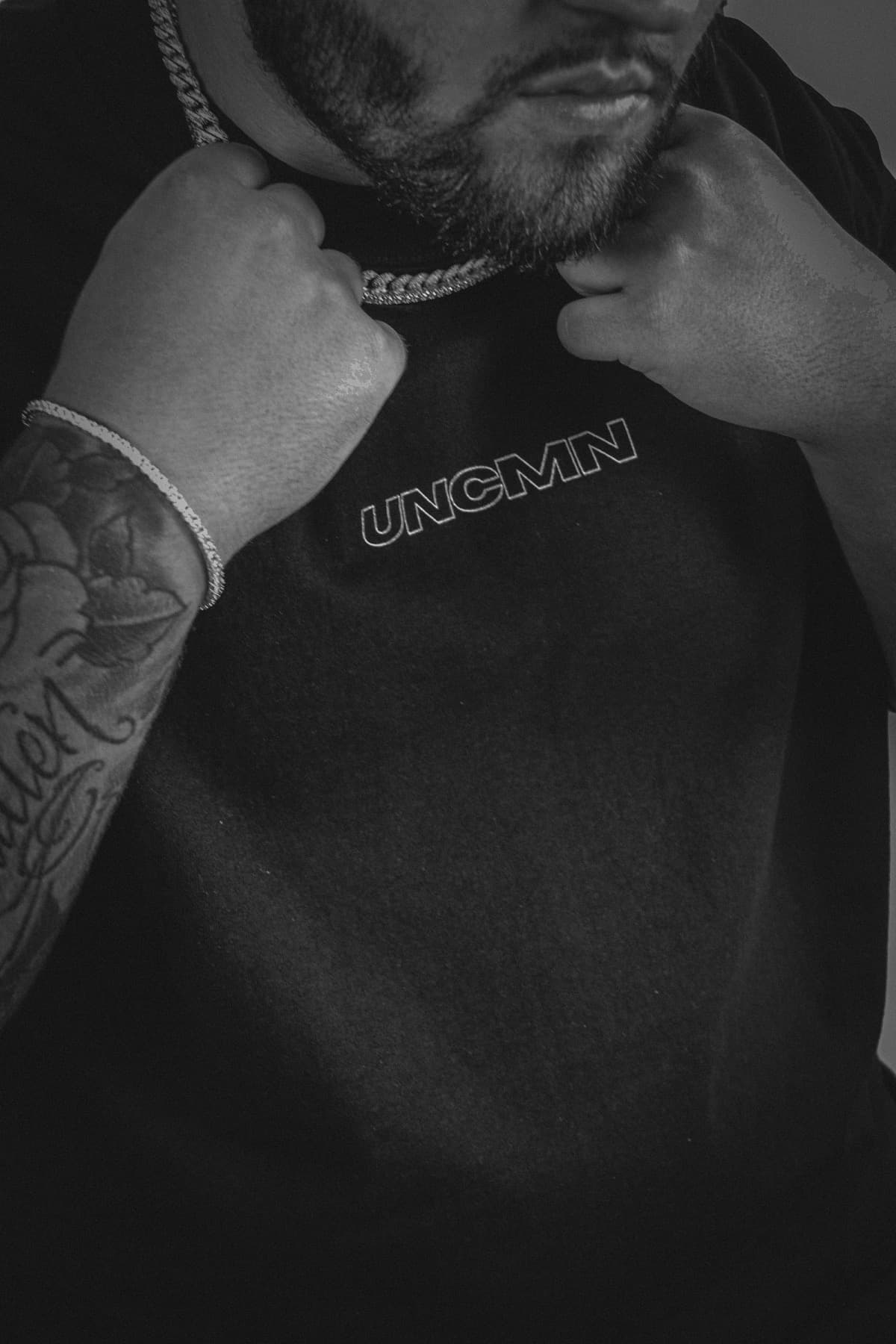 Model wearing the black UNCMN tee